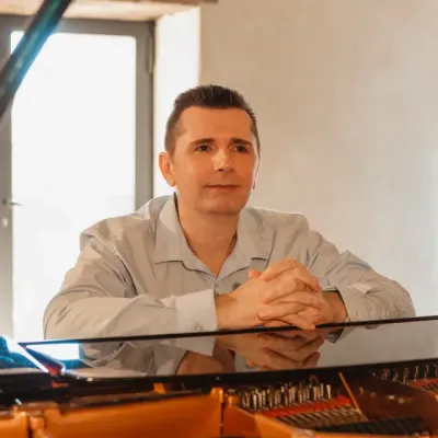 Stéphane les mains croisées, sur le piano de Rebecca Chaillot